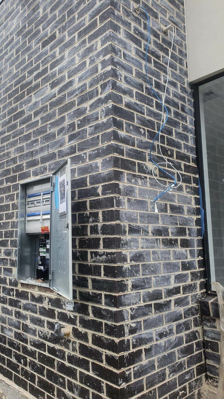 New home construction showing dark brickwork covered in excess mortar requiring Brick Cleaning.